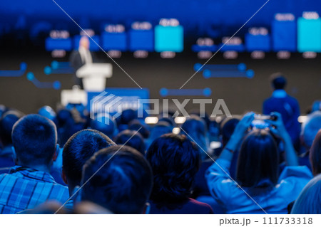 Professional speaker at conference podium addressing an audience 111733318