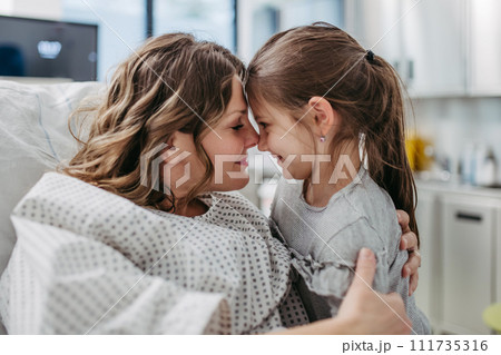 Daughter visiting mother in hospital after surgery. Emotional support from family for patients in hospital. Daughter visiting mother in hospital after surgery. Emotional support from family for patients in hospital. 111735316
