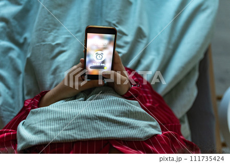Woman setting alarm before going to sleep. Concept of sleep routine. Insomnia a sleep problems among adults. 111735424