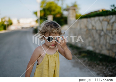 Portrait of blonde girl in summer outfit on walk during summer vacation, concept of beach holiday. Portrait of blonde girl in summer outfit on walk during summer vacation, concept of beach holiday. 111735696