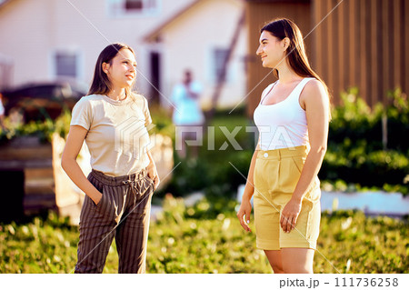 Caucasian women in their 20s met on village street and started talking on summer day. 111736258