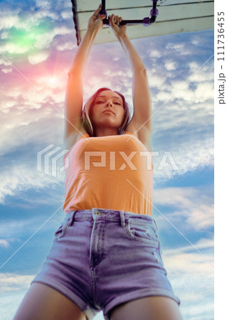 Young woman fixes an external water pipe leak by tightening nut of compression fitting. 111736455