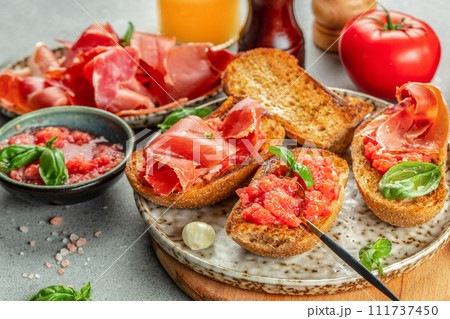 Spanish breakfast. Jamon Iberico ham and tomate bread with coffee and juice on a light background 111737450