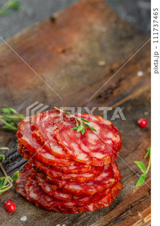 Salami sausage slices dry cured pork sausage chorizo on a wooden board Salami sausage slices dry cured pork sausage chorizo on a wooden board 111737465