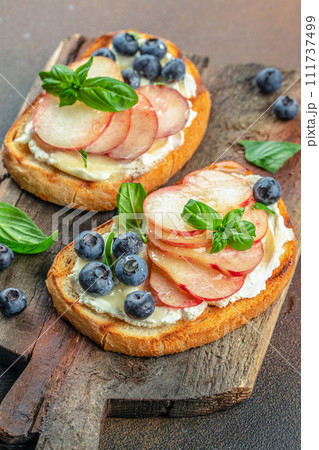 Sweet toast with ricotta cheese, honey and peach on a wooden board, Food recipe background. Close up 111737499
