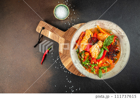 Bowl with squid, pepper and tomatoes, Italian Traditional Dish on a dark background. top view. copy space for text Bowl with squid, pepper and tomatoes, Italian Traditional Dish on a dark background. top view. copy space for text 111737615