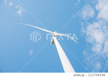 A serene scene of windmill farm turbines on a mountain demonstrates clean energy innovation. Modern technology supports sustainable development under the endless blue sky. A serene scene of windmill farm turbines on a mountain demonstrates clean energy innovation. Modern technology supports sustainable development under the endless blue sky. 111738286