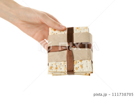 PNG, Matzo with ribbon in hand, isolated on white background 111738705