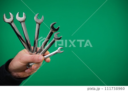 Metal double-sided open-end wrench with chrome-plated tool for connecting and disconnecting threaded connections. advertising Green background chromakey free space Metal double-sided open-end wrench with chrome-plated tool for connecting and disconnecting threaded connections. advertising Green background chromakey free space 111738960