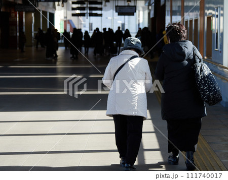 冬の松本駅の建物の中で歩く二人のシニア女性の姿 冬の松本駅の建物の中で歩く二人のシニア女性の姿 111740017