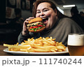 Fat girl eating hamburger in fast food restaurant.  111740244