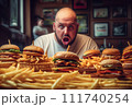 Fat man eating hamburger in fast food restaurant.  111740254