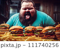 Fat man eating hamburger in fast food restaurant.  111740256