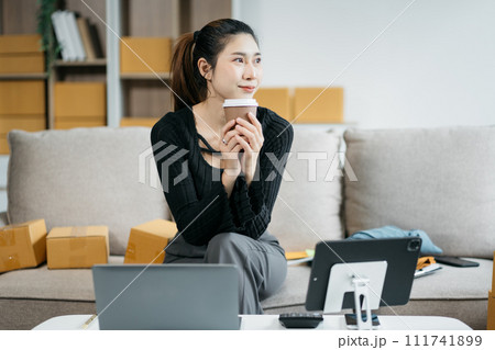 Young asian Woman Thinking and Working on sell online in cozy house, Modern Lifestyle of New Generation People. Young asian Woman Thinking and Working on sell online in cozy house, Modern Lifestyle of New Generation People. 111741899
