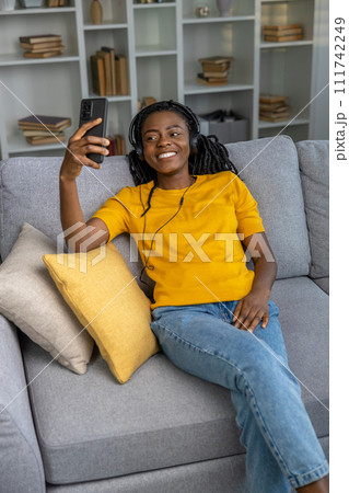 Smiling cute young woman spending time at home and looking happy Smiling cute young woman spending time at home and looking happy 111742249