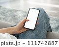 Woman hand holding smartphone mockup of blank screen for graphic display montage. 111742887