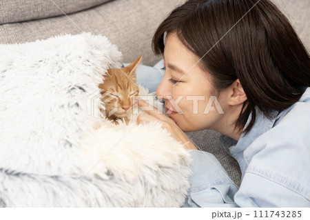 眠る仔猫の鼻を指で触れる女性 眠る仔猫の鼻を指で触れる女性 111743285