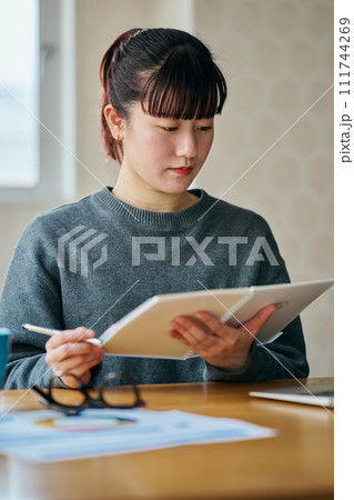 ノートを手に持ち調べごとをする若い女性 ノートを手に持ち調べごとをする若い女性 111744269