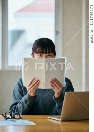 ノートを手に持ち見つめる若い女性 ノートを手に持ち見つめる若い女性 111744273
