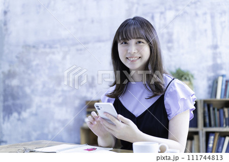 勉強中にスマホを使う若い女性 111744813