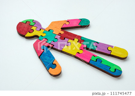 A figurine of a man made from colored puzzle pieces. Unity or neurodiversity concept. 111745477