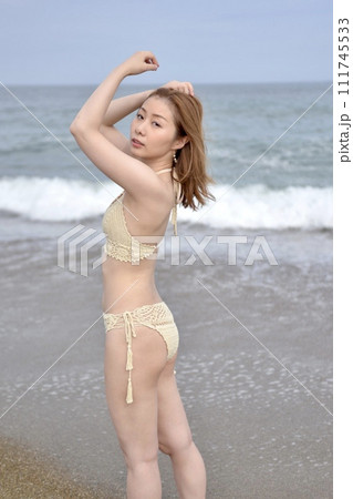 海岸にてビキニの水着を着た若い女性 111745533