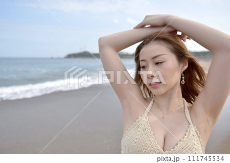 海岸にてビキニの水着を着た若い女性 111745534