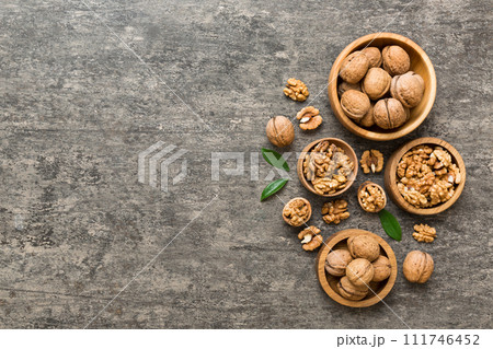 Walnut kernel halves, in a wooden bowl. Close-up, from above on colored background. Healthy eating Walnut concept. Super foods with copy space 111746452