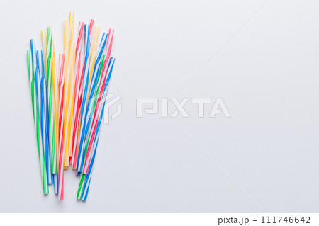 Heap of colorful plastic drinking straws on Colored background, flat lay. Copy Space for text 111746642