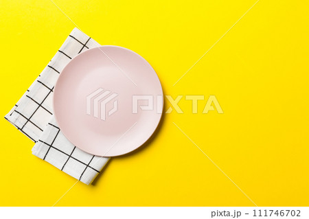 Top view on colored background empty round pink plate on tablecloth for food. Empty dish on napkin with space for your design 111746702