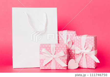 Shopping bag with gift box on colored background perspecrive view. Space for text holiday concept Shopping bag with gift box on colored background perspecrive view. Space for text holiday concept 111746750