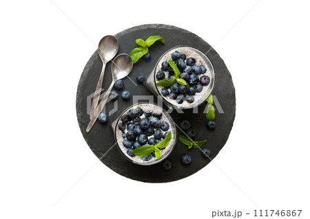 Healthy breakfast or morning with chia seeds vanilla pudding and blueberry berries on table background, vegetarian food, diet and health concept. Chia pudding with coconut milk and blueberry Healthy breakfast or morning with chia seeds vanilla pudding and blueberry berries on table background, vegetarian food, diet and health concept. Chia pudding with coconut milk and blueberry 111746867