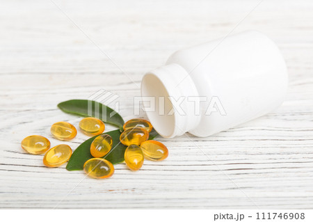 Omega-3 capsules lie in white bottle on a table background. Fish oil tablets top view. Biologically active additives. omega 6, omega 9, vitamin A, E, vitamin D, vitamin D3, evening primrose oil 111746908