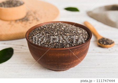 Chia seeds in bowl and spoon on colored background. Healthy Salvia hispanica in small bowl. Healthy superfood 111747444