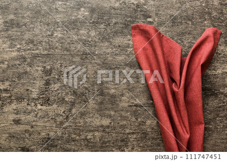 top view with red empty kitchen napkin isolated on table background. Folded cloth for mockup with copy space, Flat lay. Minimal style 111747451