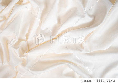 Waves and patterns of crumpled natural satin white milk color fabric. 111747638
