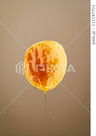 One pancake in honey on a brown background 111747731