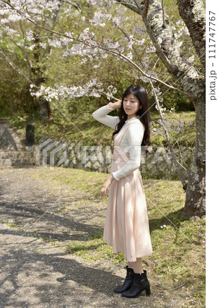 サクラ咲く公園でポーズをとる若くスリムな女性 サクラ咲く公園でポーズをとる若くスリムな女性 111747767