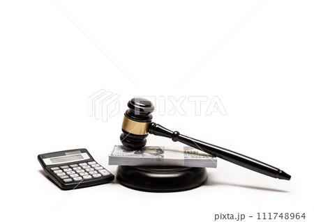 An isolated image of a judge's gavel on a stack of cash with a calculator, signifying legal fines or bail. 111748964