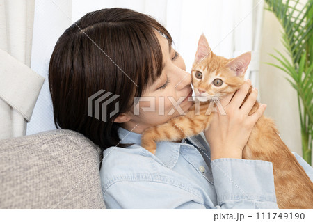 仔猫と頬を寄せて微笑む女性 111749190