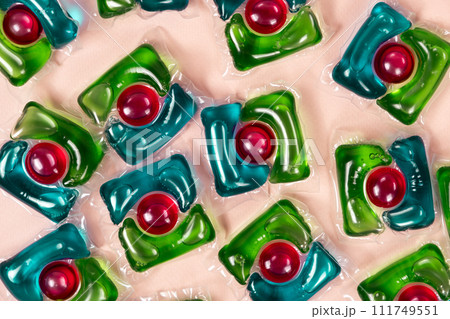 Laundry capsules on beige background close-up 111749551