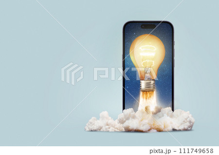 Creative burning light bulb takes off with smoke and blast from a smartphone on a blue background. Overflow, concept. Think differently. Application development and start-up launch, creative idea Creative burning light bulb takes off with smoke and blast from a smartphone on a blue background. Overflow, concept. Think differently. Application development and start-up launch, creative idea 111749658