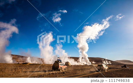 Sunshine Boivian desert landscape with steaming geysers and cars Sunshine Boivian desert landscape with steaming geysers and cars 111749838