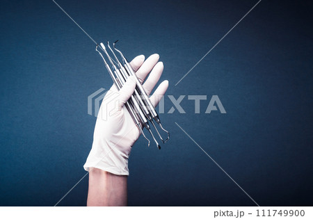 Hand in glove holding medical tools 111749900