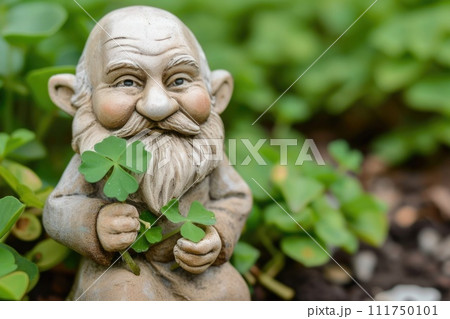Leprechaun holding green shamrock and clover leaves outdoor in garden 111750101