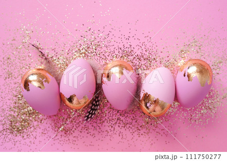 Easter party concept. Easter eggs with golden glitter on pink background Easter party concept. Easter eggs with golden glitter on pink background 111750277