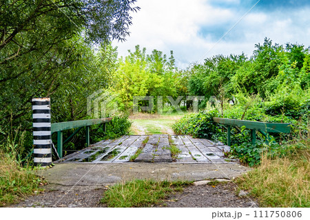 Beautifully standing old wooden bridge over river in colored background close up 111750806