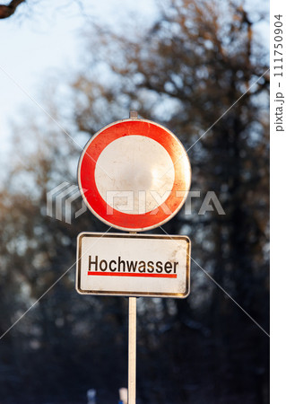 Water flood sign Hochwasser - Flood at Germany forest city park. Road close drive prohibited due Weather seasonal disaster. Climate change consequence Water flood sign Hochwasser - Flood at Germany forest city park. Road close drive prohibited due Weather seasonal disaster. Climate change consequence 111750904