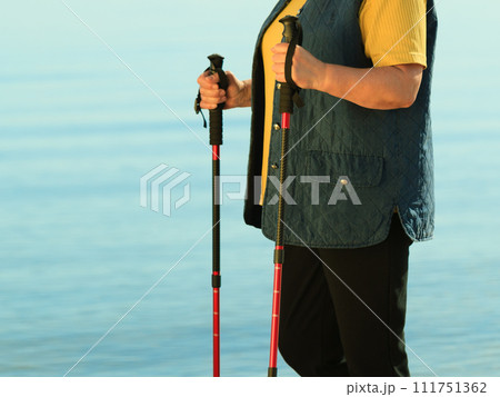 active woman senior nordic walking on a beach 111751362