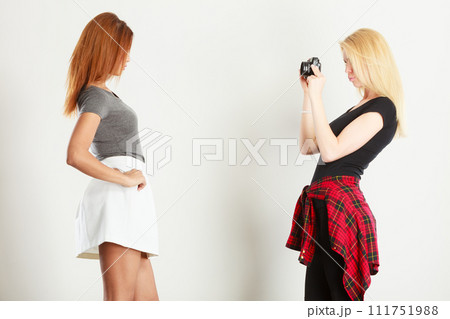 Blonde girl photographing mulatto woman 111751988